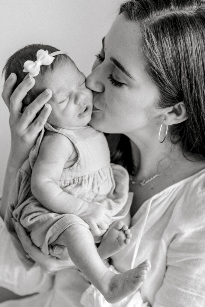 Mom kissing newborn baby's face