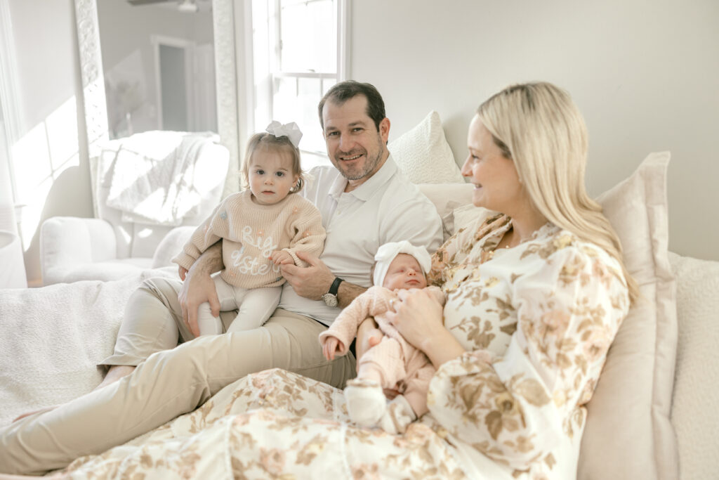 Family sitting on bed looking at camera