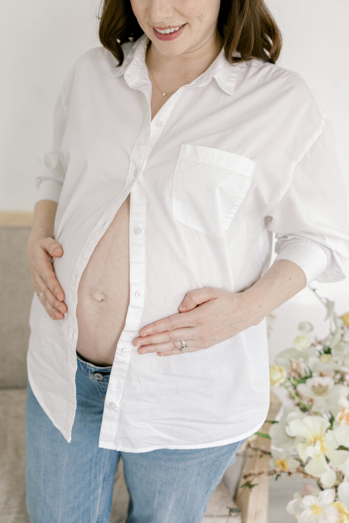 Close-up of pregnant  mother holding her belly during a Northern Virginia motherhood session