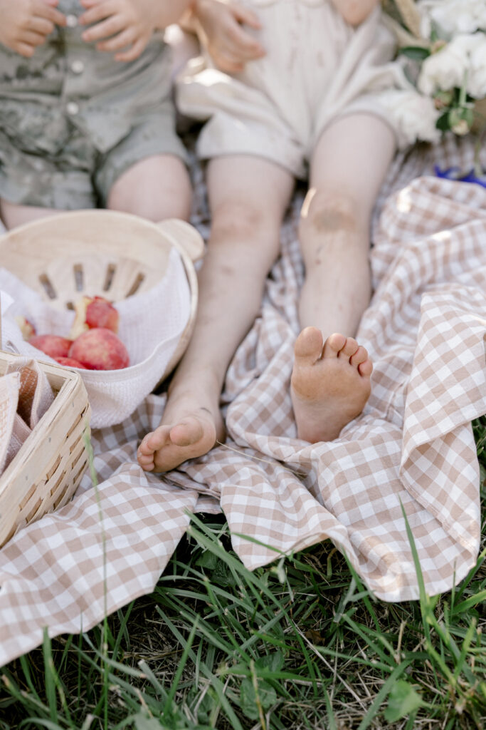 Child feet on a picnic blanket