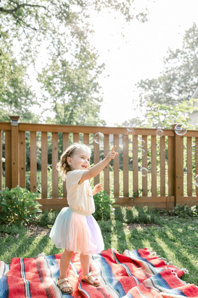 A toddler chasing giant bubbles at sunset, showcasing magical summer family photo ideas in Northern Virginia.
