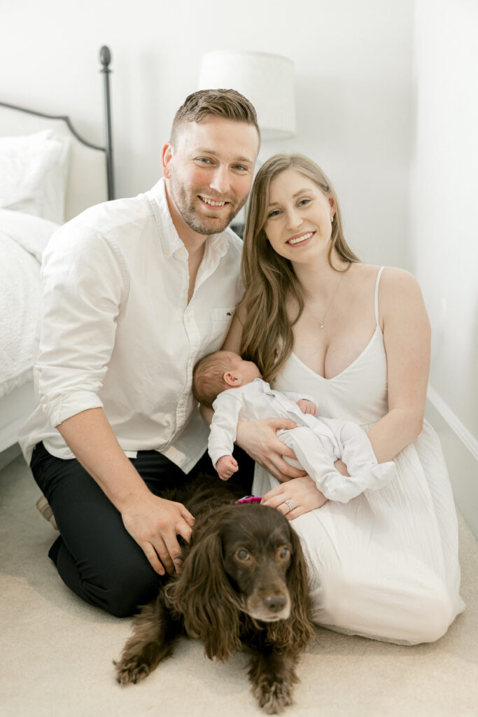 Parents lovingly holding their newborn baby in a cozy Old Town Alexandria bedroom