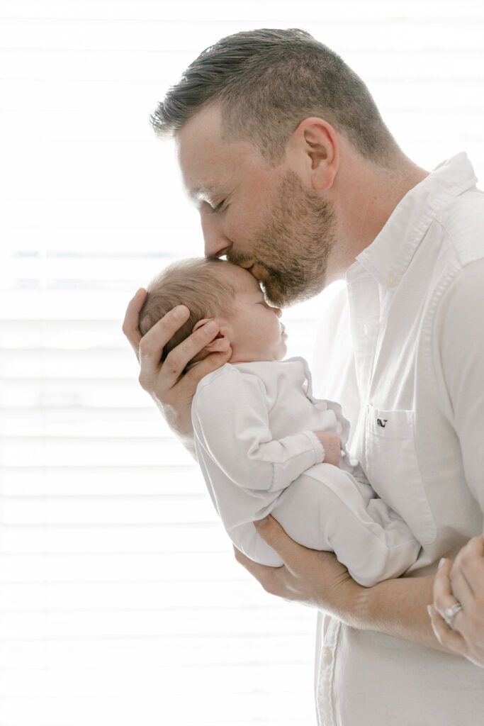 Father cradling newborn baby in Old Town Alexandria home