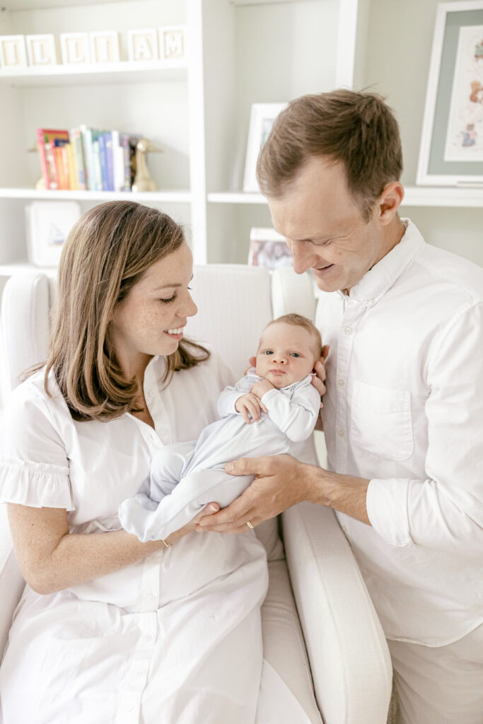 Woman and man smiling down at their newborn baby boy.