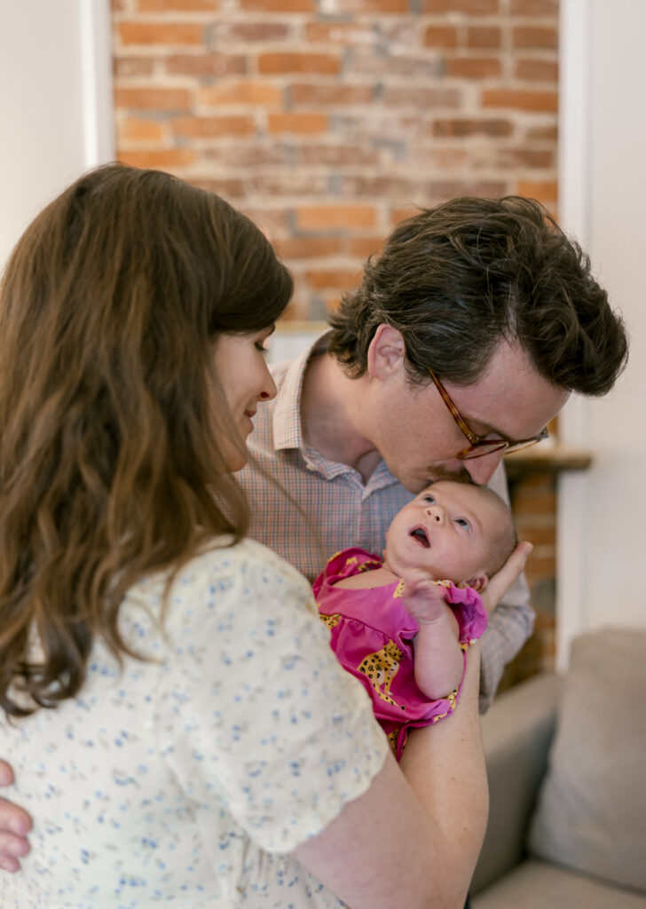 Father kissing the top of newborn baby's head