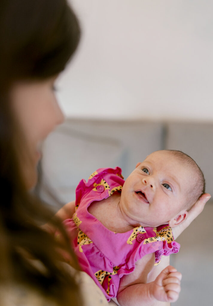Newborn baby looking up at mother during in-home newborn photography in DC