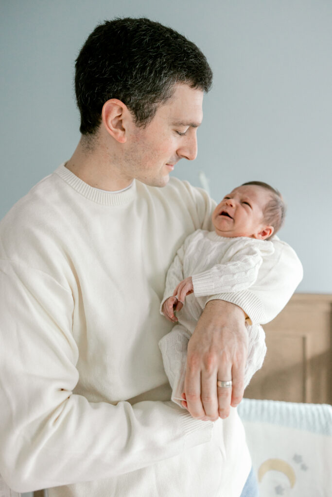Father holding newborn baby during in-home photography session in Alexandria VA