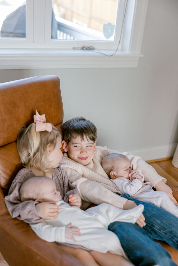 Older brother and sister with their newborn twin siblings during an Arlington VA newborn session