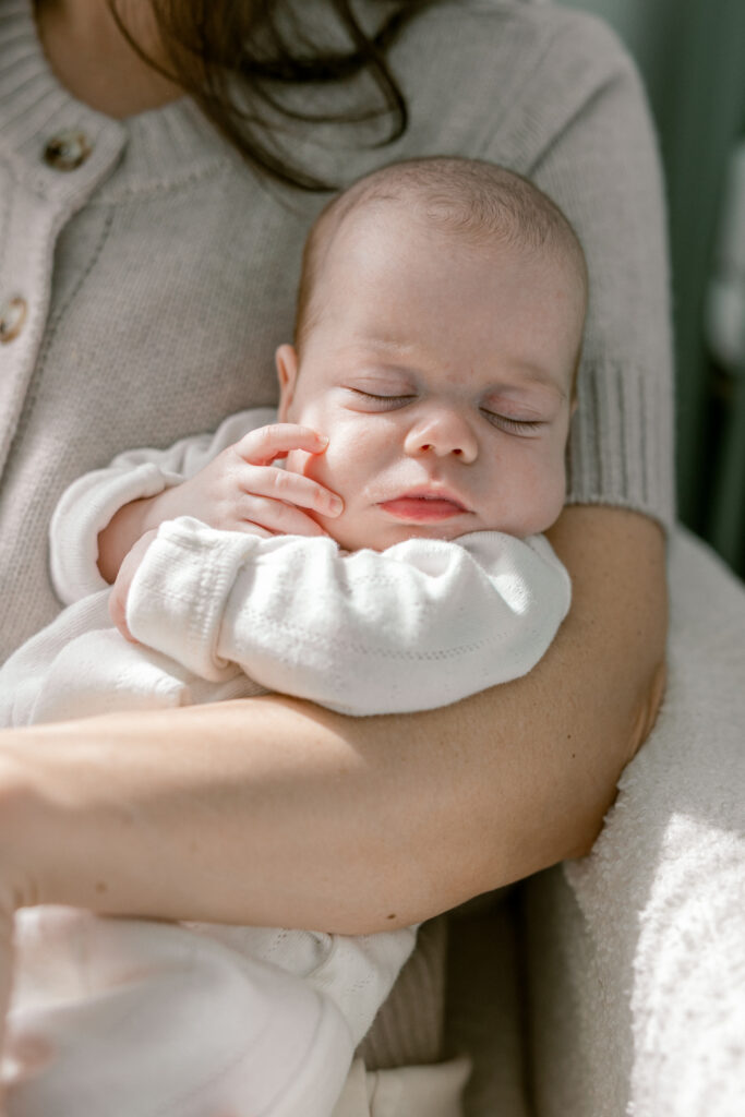 Close up of baby while mom holds her in her arms.