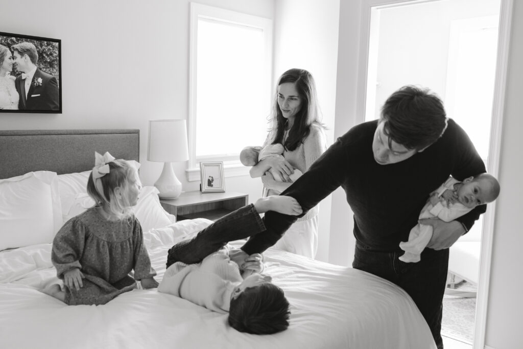 Mom looking at kids during a newborn twin photo session.